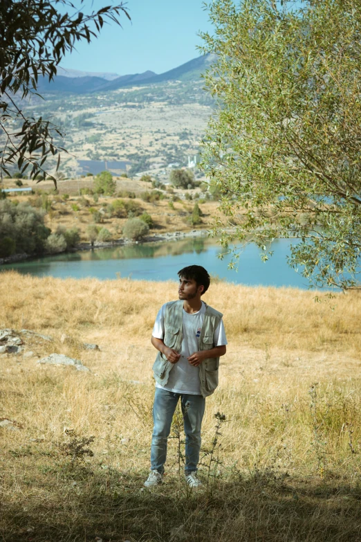 a man is posing for a picture near the water