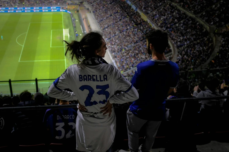 two young women watching soccer in a stadium
