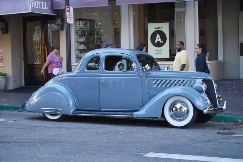 a blue car parked in front of a store