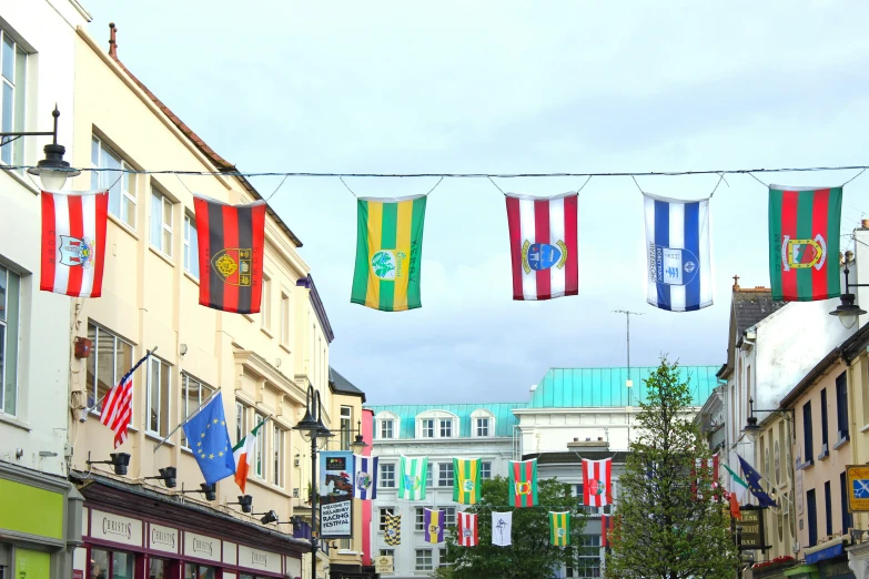 flags are hung on a line along an urban street