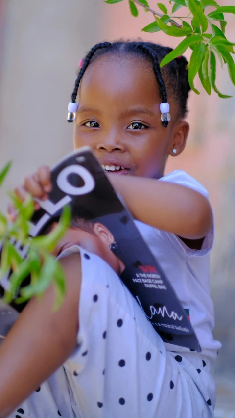 the girl is posing with her book outside