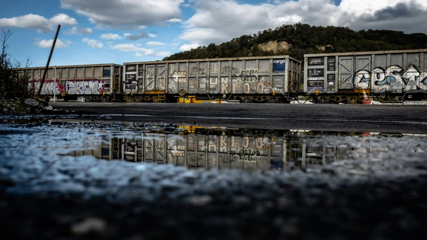 a train with graffiti is parked at a stop