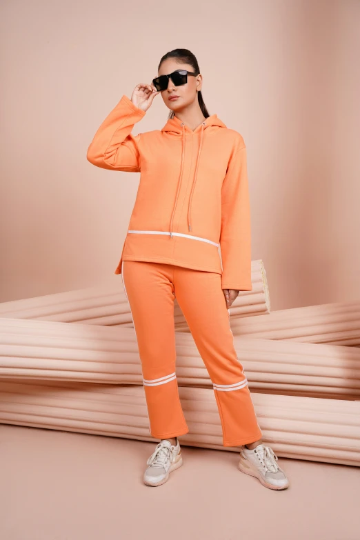 a woman in an orange track suit is posing for the camera