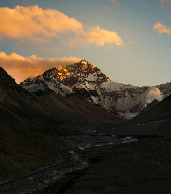 a landscape s of the sun setting over a mountain peak