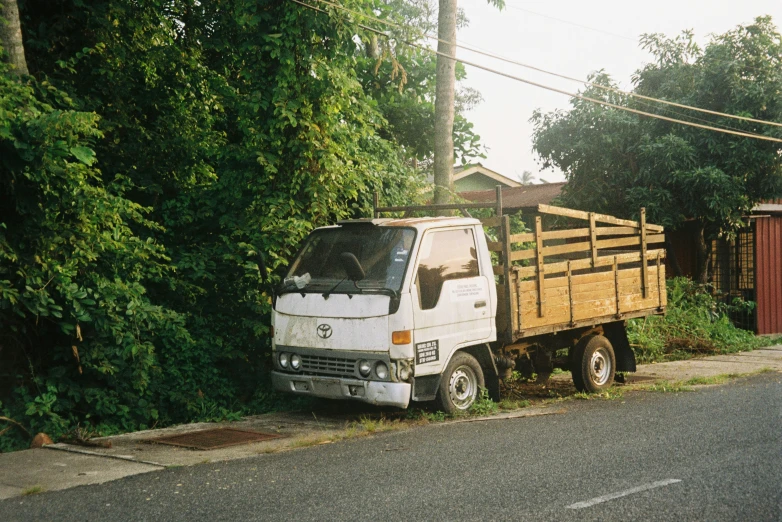 an old white truck parked on the side of a road