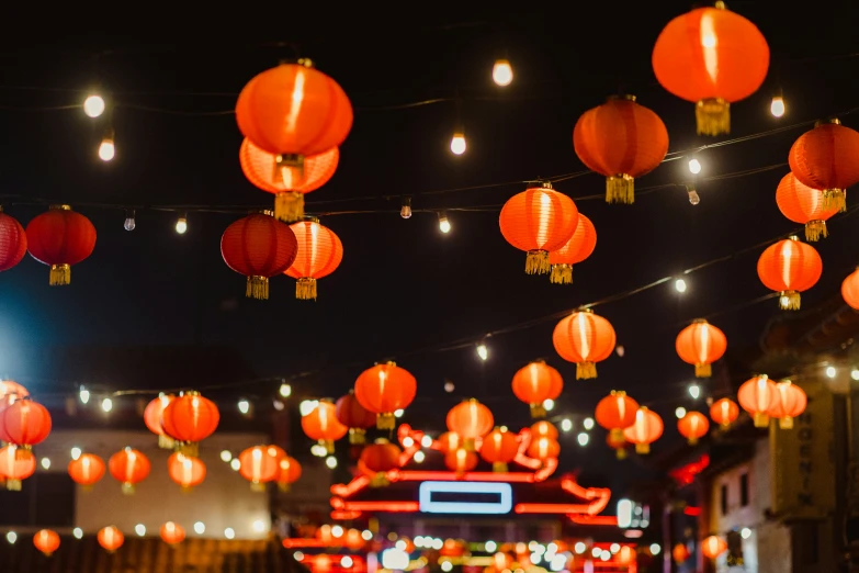 many red lantern like paper lanterns hanging over a street