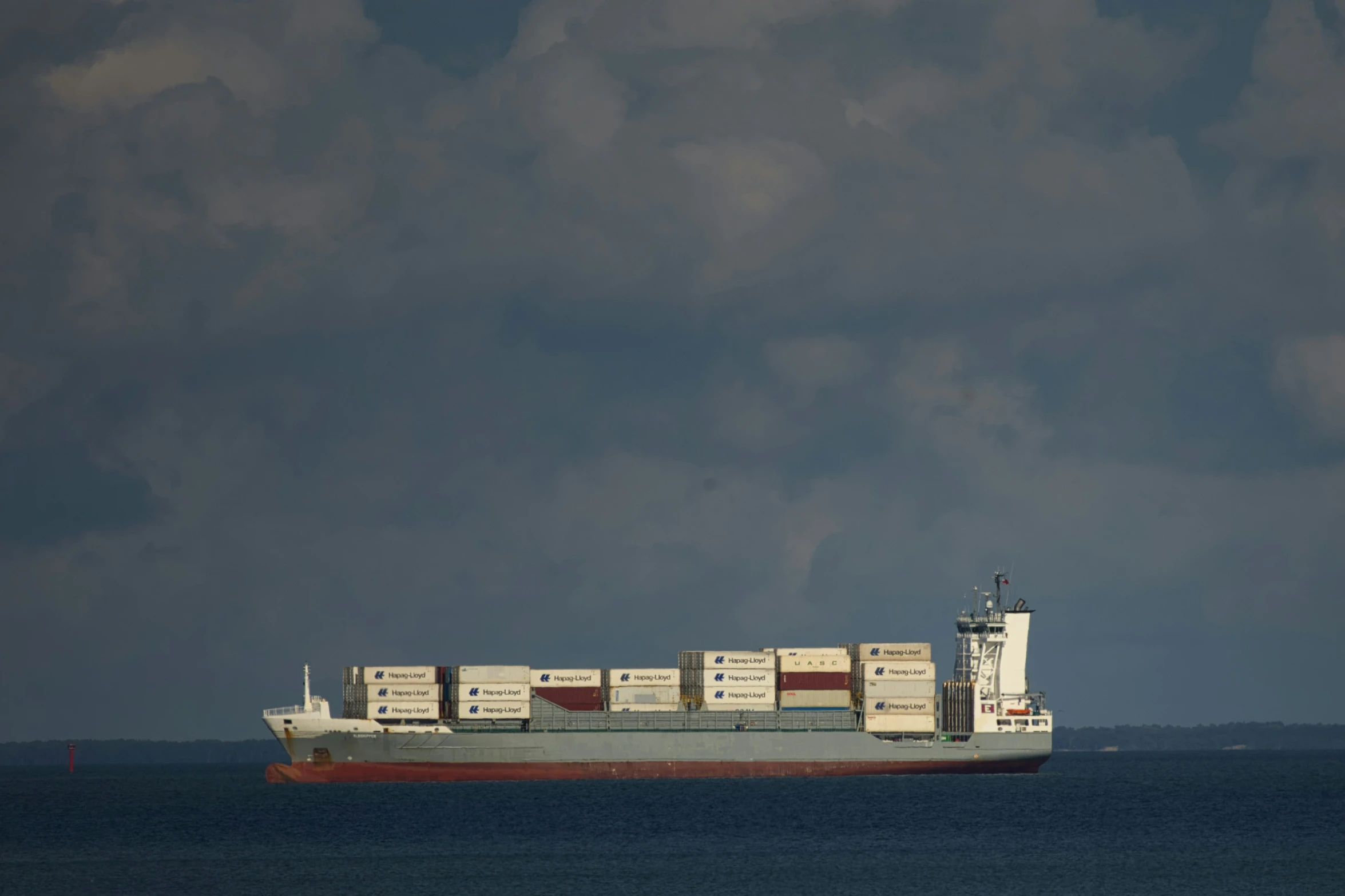 the container ship is traveling through the open ocean