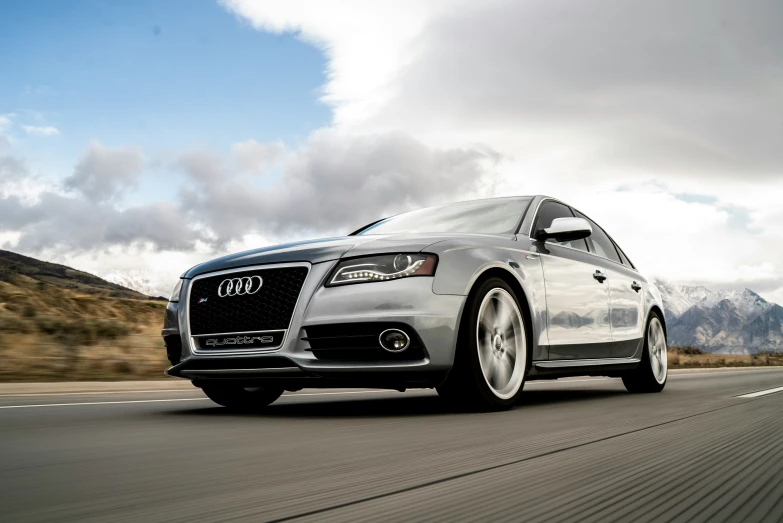 an all white car driving along a road