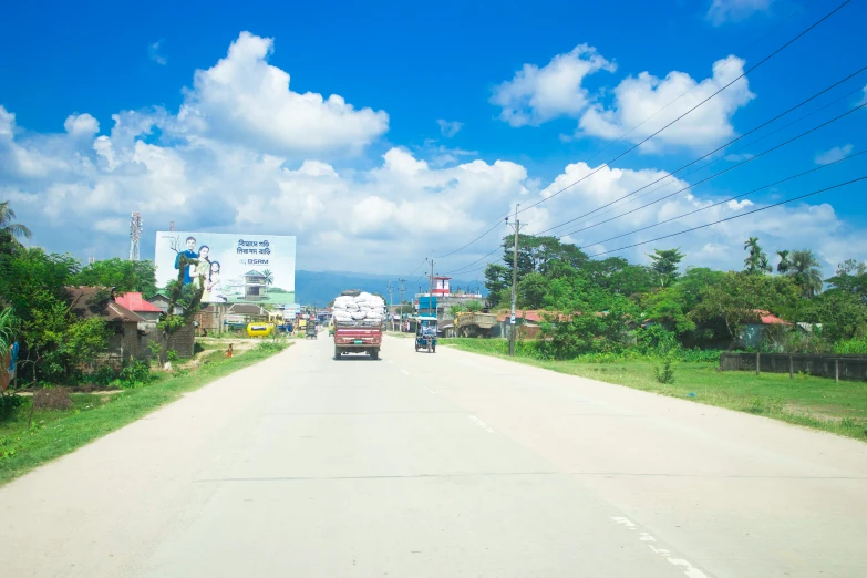 cars and trucks drive along an empty country road