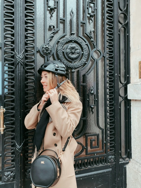 woman with a hat leaning on a black door