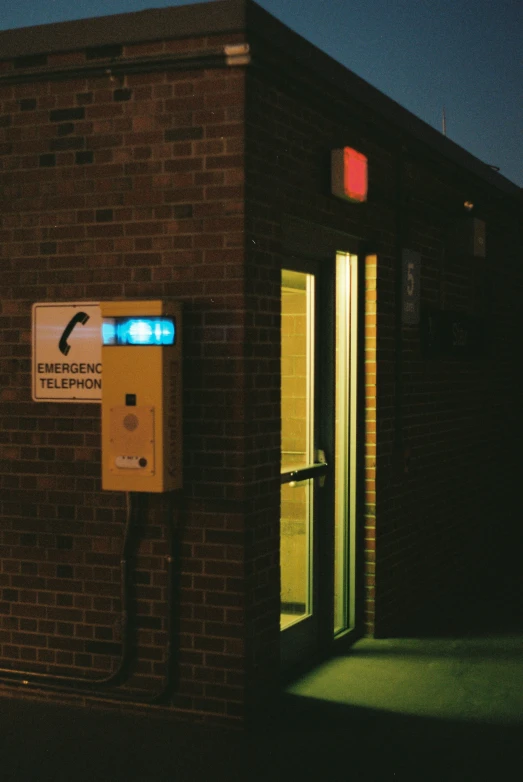 an illuminated parking meter and door on a brick building