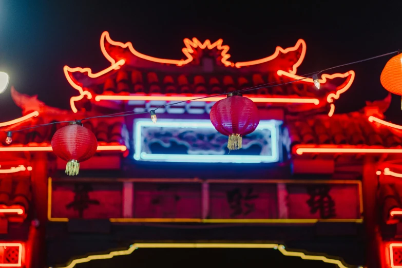 red lanterns in the middle of a building with a sky view