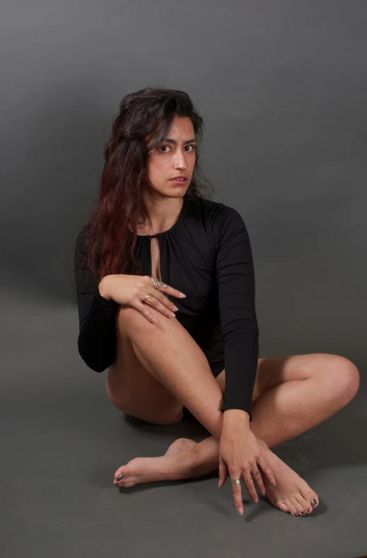 a woman posing for the camera on a grey background