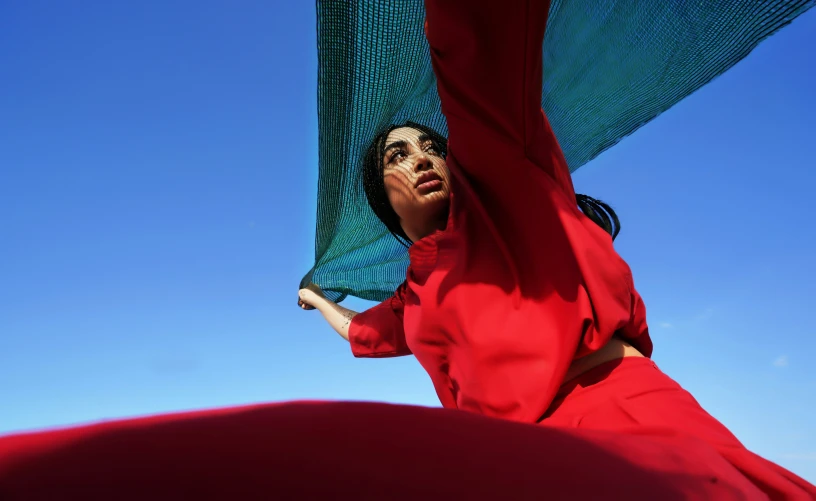 a woman in red poses on top of an object