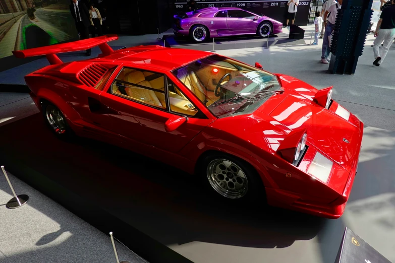 red sports car parked in front of two other cars