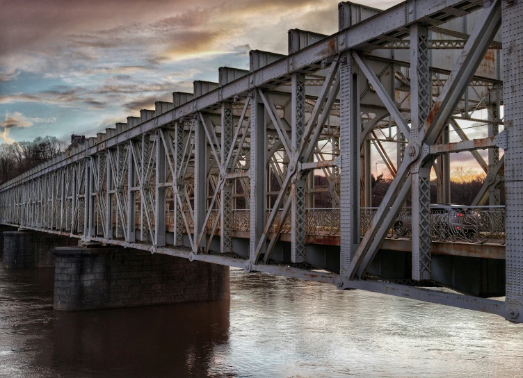 a train bridge is pictured on the side of the river