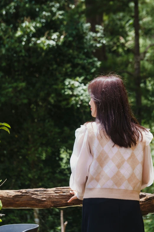 a woman looking out at the trees in her backyard