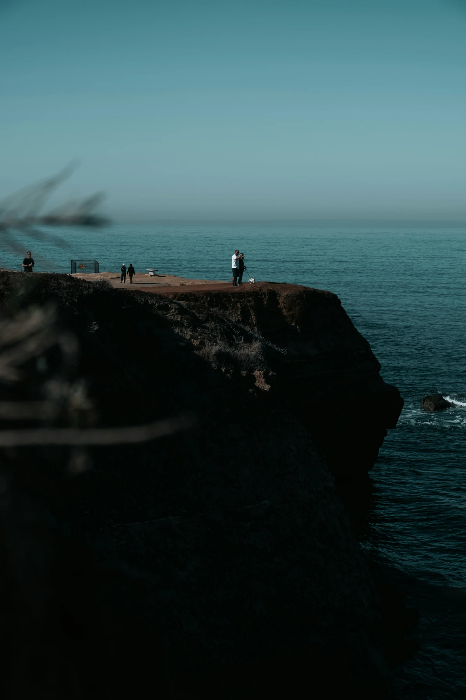 there is an ocean view with people walking on a rock