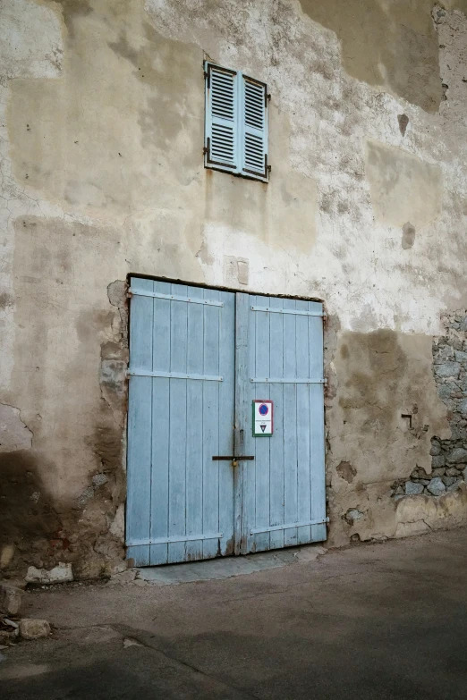 a white and blue building with two blue doors