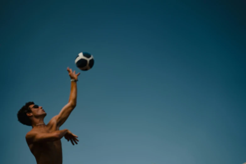 a man jumps into the air with his shirt on and the ball in his hand