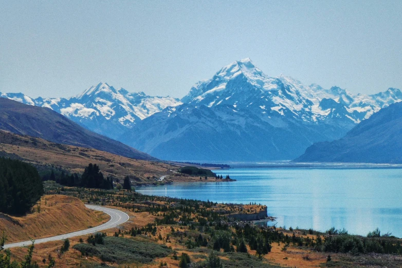 a road winds through an area with mountains in the background