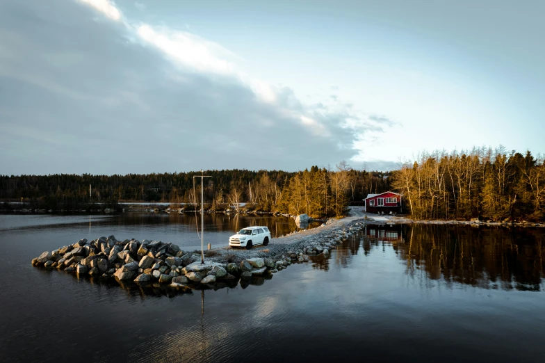 the van is parked on the end of the dock by the water