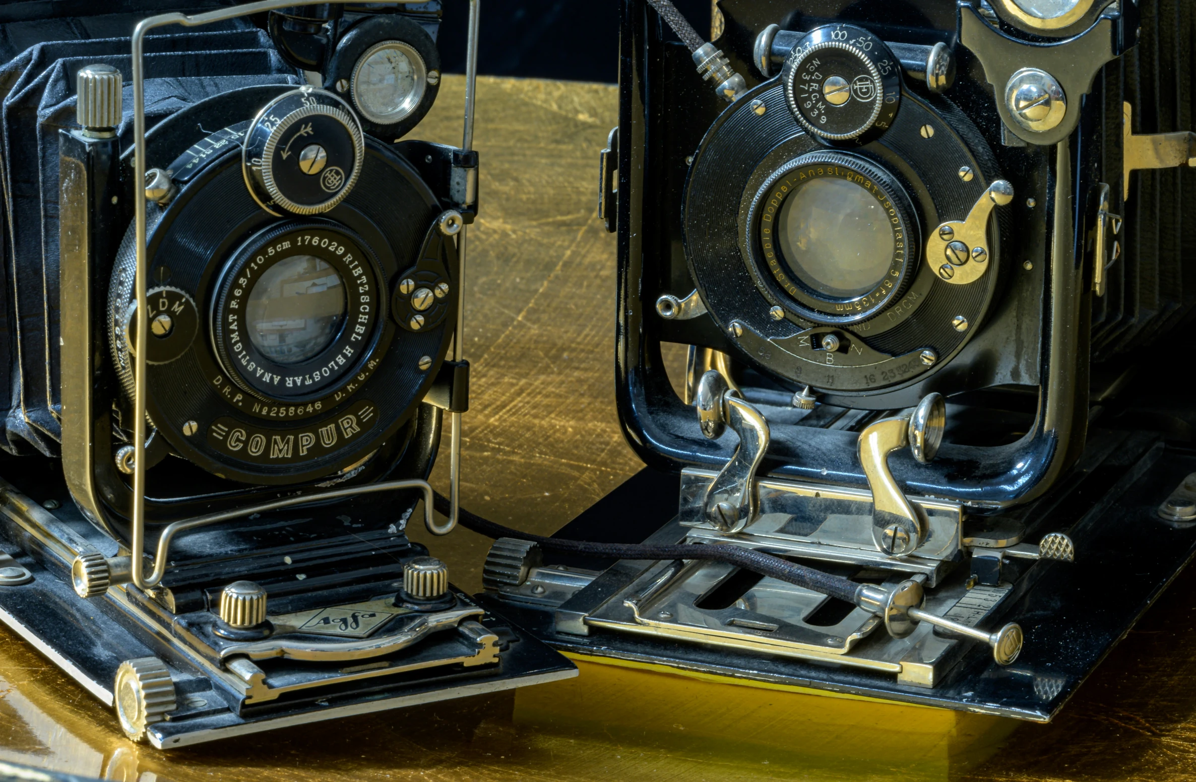 two old black cameras sitting side by side on a table