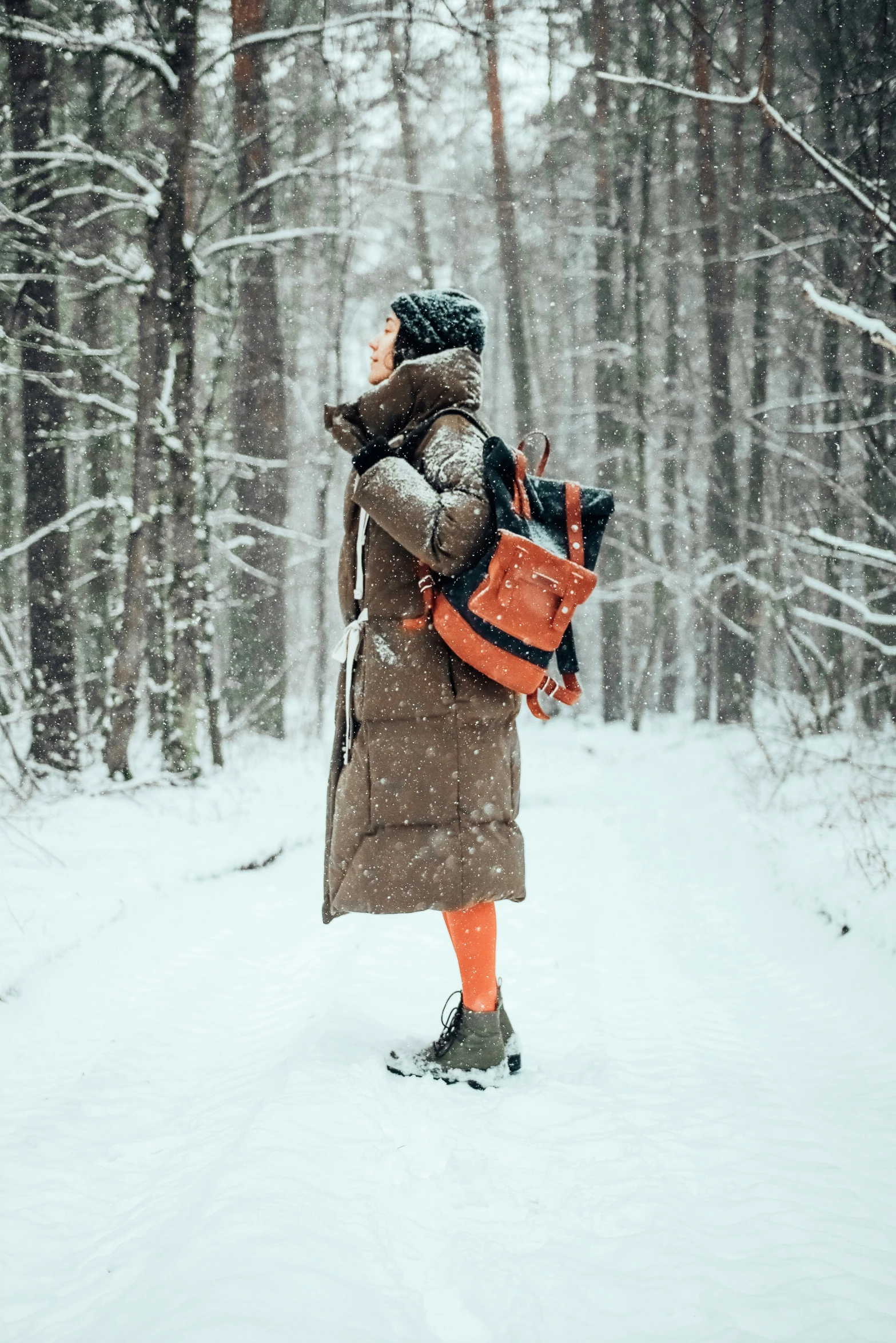 a woman walking through the woods with a backpack on her back