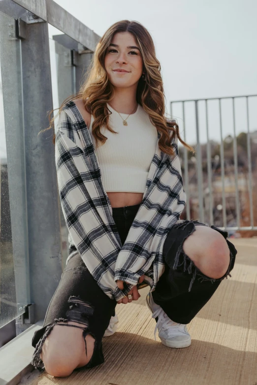 young woman in plaid cardigan sitting on deck