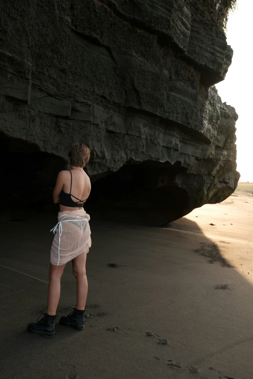 a person standing on the sand next to the water