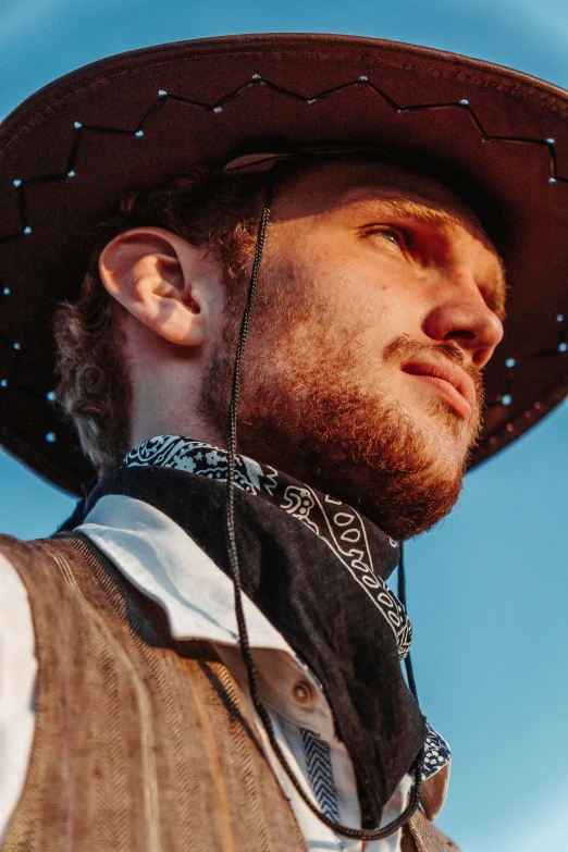 man with a cowboy hat looking back at the camera