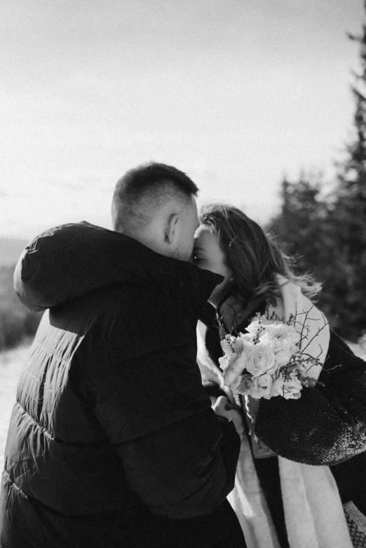 the man kisses the woman outside in the snow