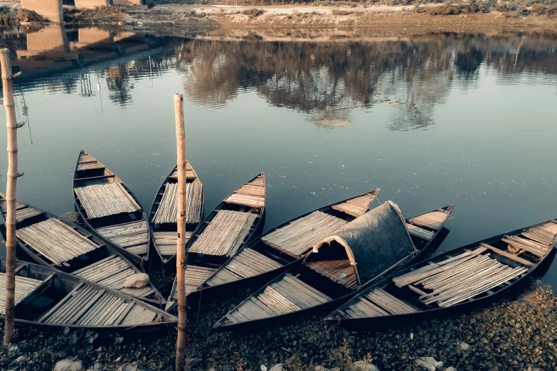 some canoes are docked on the water near the shore