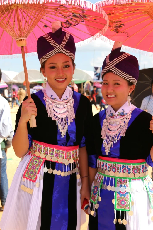 two women wearing traditional dress and holding umbrellas