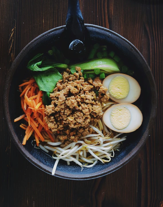 a bowl full of food with eggs on top