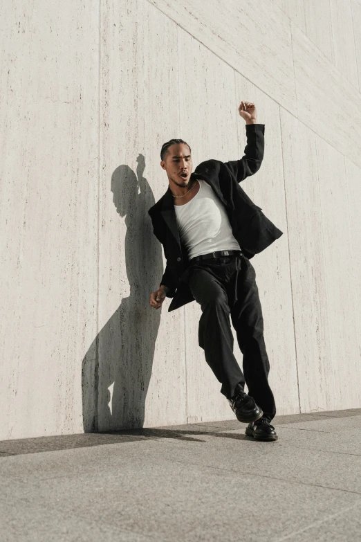 a man that is standing in front of a wall