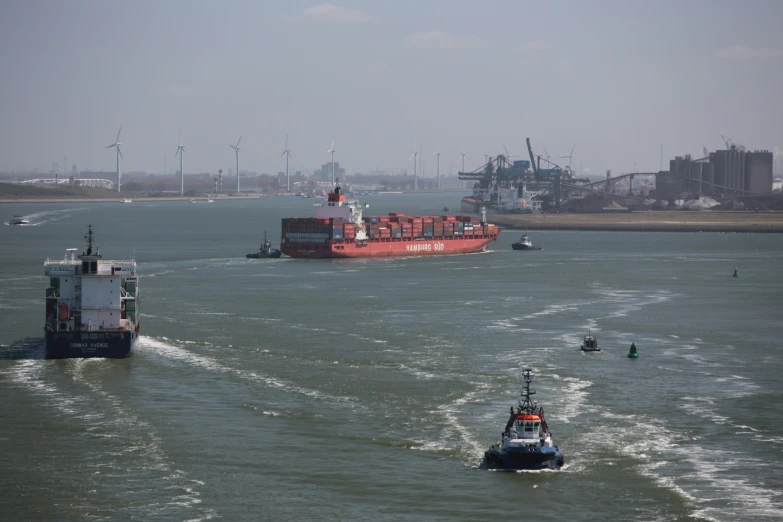a large boat in the water next to a tug boat