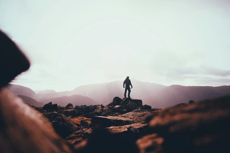 a person standing on top of a mountain with mountains in the background