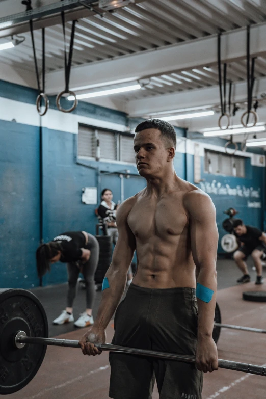 a shirtless man is in the gym with bars