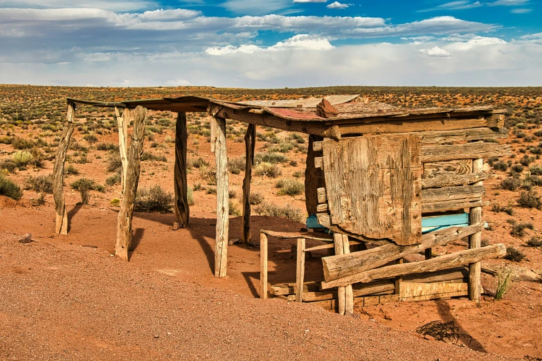 a outhouse sits in the middle of a desert