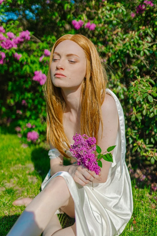 a woman in white sitting down with flowers