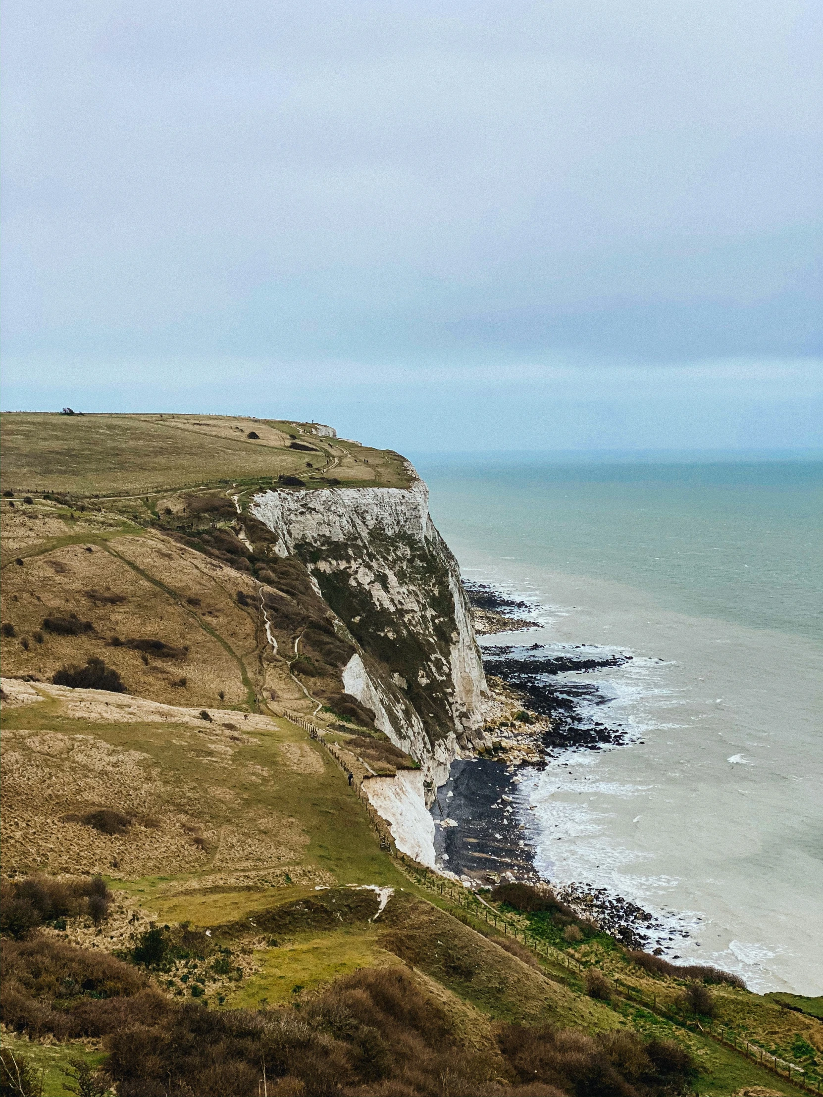 view of the cliffs from above a beach and ocean