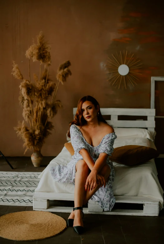 a young woman sitting on a bed in a dimly lit room