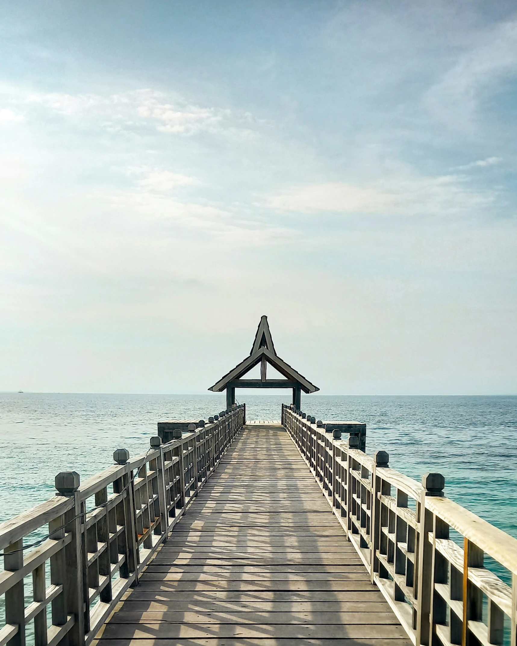 a small pier with benches on it over looking the water