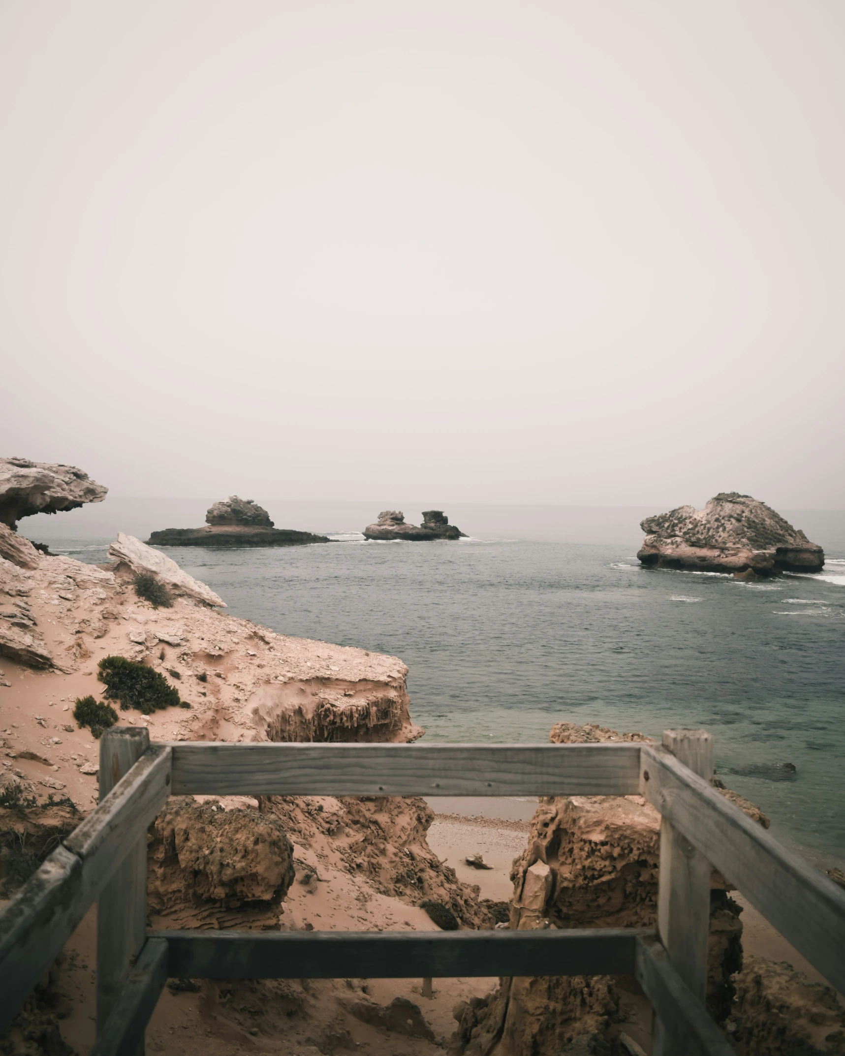 a wooden fence sitting on top of a beach