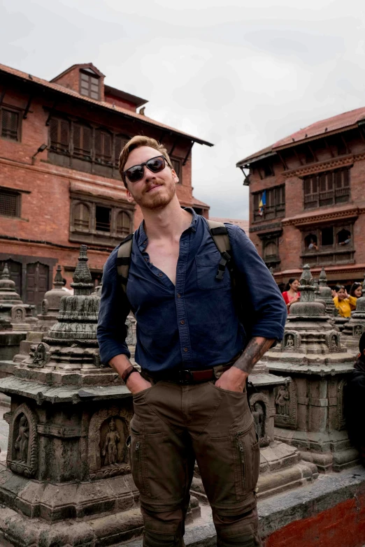 man in large jeans and a backpack standing on stone steps