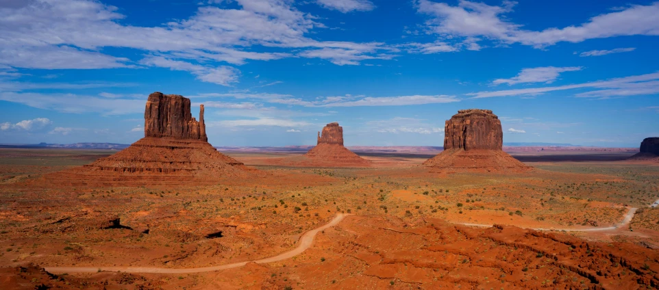 a desert landscape with rocks, dirt roads and hills in the background