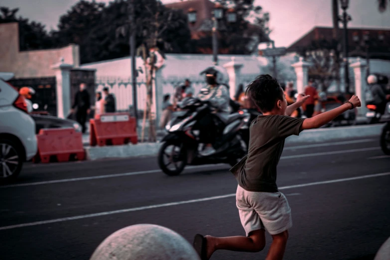 a boy is playing tennis in the street