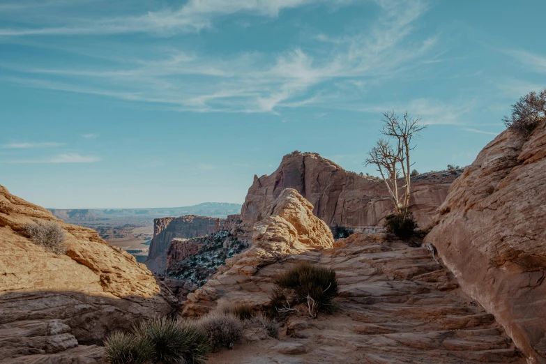 a rocky path surrounded by mountains and trees