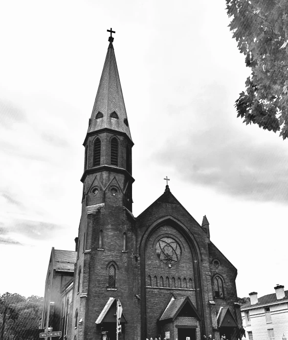 an old gothic style church with steeple is featured in black and white